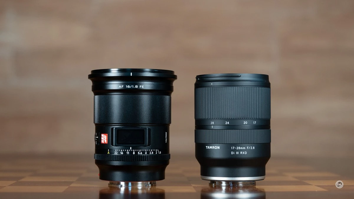 Повнокадровий об'єктив Viltrox AF 16mm f/1.8 FE з ручним кільцем діафрагми та вбудованим LCD-екраном поряд із зумом Tamron 17-28mm на дерев'яному столі